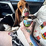 basset_hound, puppy, dog, pet, car_interior, person, hand, tattoo, mickey_mouse, shirt, shorts, cup, licking, cute, animal, indoor, seat, window, stop_sign, petco_sign