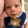 Jahmel is registered to the contest to win money with this photo: baby, bear, bib, blanket, blue, closeup, clothing, cute, embroidery, expression, face, hand, indoors, infant, person, pink, portrait, resting, soft, young