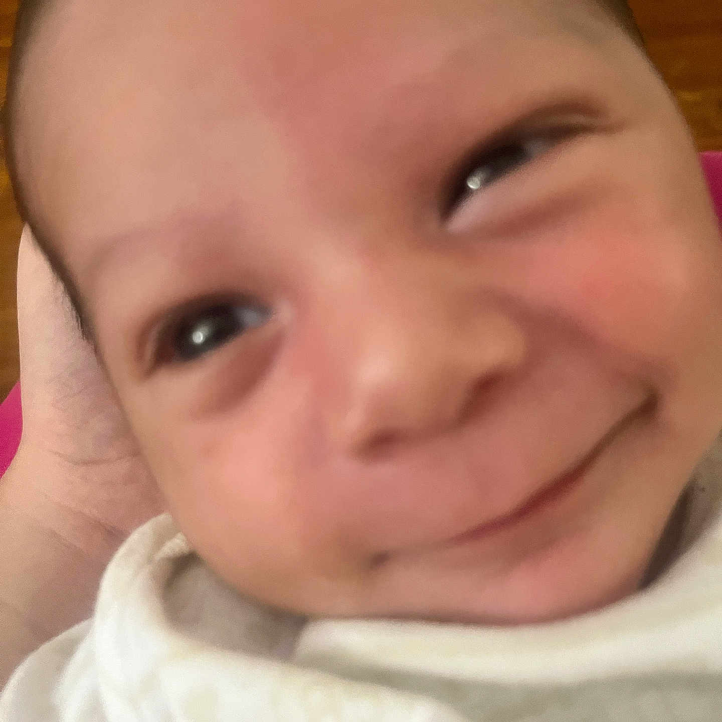 Jahmel is registered to the contest to win money with this photo: baby, baby_face, cheeks, close_up, cute, expression, face, hand, head, human, infant, looking_up, newborn, person, portrait, skin, smile, soft, white_clothing, young_child