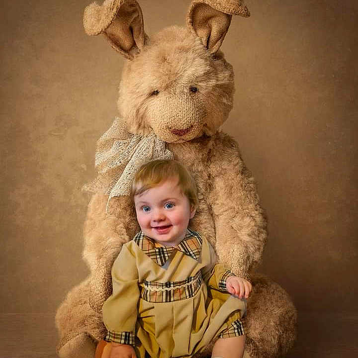 Reuben is registered to the contest to win money with this photo: baby, blonde, clothing, coat, costume, dress, face, hair, happy, head, indoors, jacket, people, person, photography, portrait, sitting, smile, teddybear, toy