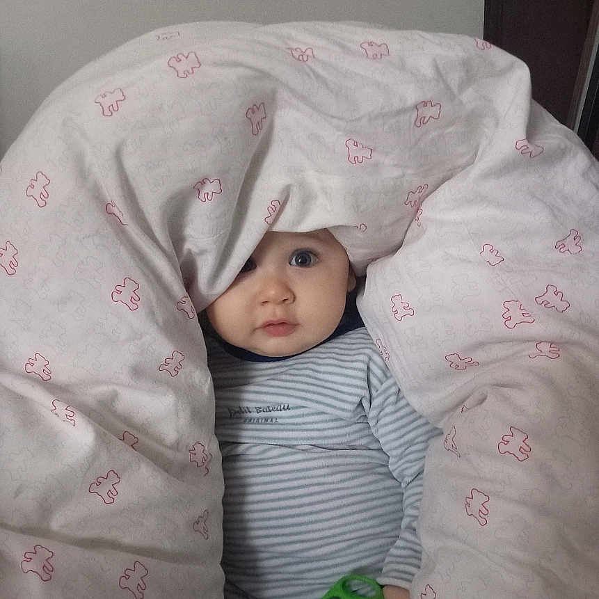 Naël participe au concours pour gagner de l'argent avec cette photo : baby, blanket, child, comfort, curious, cushion, cute, face, hand, indoor, infant, peeking, portrait, resting, soft, striped_clothing, teddy_bear_pattern, toy, wide_eyes, young_child