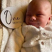 Kasper joined the competition — help win amazing prizes! baby, blanket, buttoned_jacket, child, closeup, cute, face, indoor, infant, milestone_card, newborn, one_month, peaceful, portrait, resting, sleepy, smiling, soft_texture, white_clothing, young