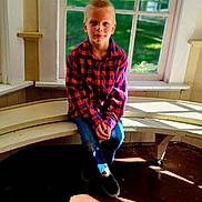 Sebastian joined the competition — help win amazing prizes! child, boy, portrait, sitting, window, indoors, sunlight, wooden_floor, bench, plaid_shirt, red_shirt, blue_jeans, shoes, blond_hair, smiling, face, home, window_seat, natural_light, photography