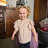 Hermione is registered to the contest to win money with this photo: child, girl, smiling, portrait, indoors, bedroom, pink_shirt, ruffled_top, pigtails, hair_bows, curly_hair, blue_jeans, necklace, earrings, standing, happy, dresser, furniture, laundry_basket, home