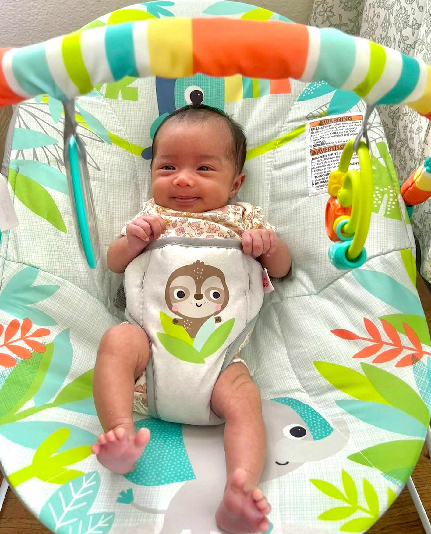 Nora joined the competition — help win amazing prizes! baby, infant, smiling, baby_bouncer, toy, colorful, animal_print, leaf_pattern, happy, cute, indoor, child, seat, playful, small_hands, small_feet, fabric, comfort, young, cheerful