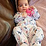 Neveah is registered to the contest to win money with this photo: baby, infant, onesie, floral_pattern, pink, toy, soft_blanket, couch, leather, relaxed, cute, child, portrait, indoors, comfort, sleepwear, small_hands, face, cozy, resting
