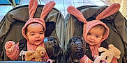 Neveah joined the competition — help win amazing prizes! baby, bunny_ears, pink_clothing, stroller, twin_babies, stuffed_animal, fan, indoor, tile_floor, cute, child, infant, face, headwear, seated, toy, adorable, matching_outfits, black_fan, happy