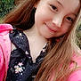 child, girl, smiling, portrait, long_hair, outdoor, nature, tree, greenery, pink_jacket, floral_dress, face, happy, earring, casual_clothing, daylight, person, cute, young, fashion