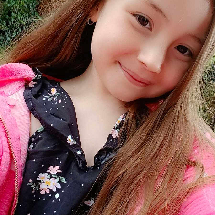 Lucinda participe au concours pour gagner de l'argent avec cette photo : casual_clothing, child, cute, daylight, earring, face, fashion, floral_dress, girl, greenery, happy, long_hair, nature, outdoor, person, pink_jacket, portrait, smiling, tree, young