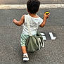 toddler, child, back_view, curly_hair, toy_car, green_bag, white_tank_top, mint_shorts, sneakers, walking, asphalt, street, sidewalk, outdoor, summer_clothing, casual, young_child, daytime, small_person, playful