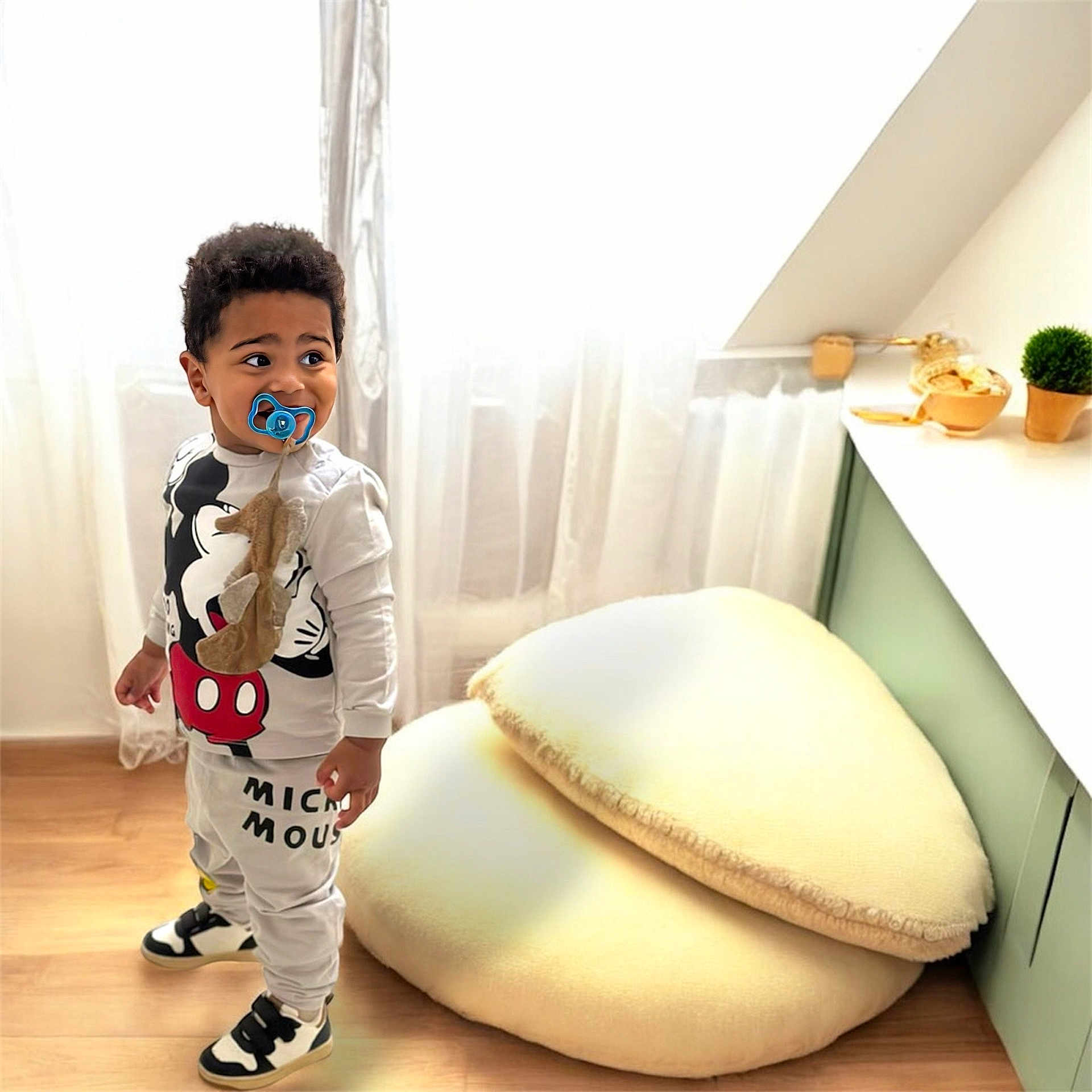 Tyler a rejoint le concours — aidez-le/la à gagner de superbes lots ! toddler, child, pacifier, mickey_mouse, clothing, sneakers, floor, cushions, curtains, window, room, furniture, cabinet, plant, decor, indoor, standing, expression, young_child, soft_lighting