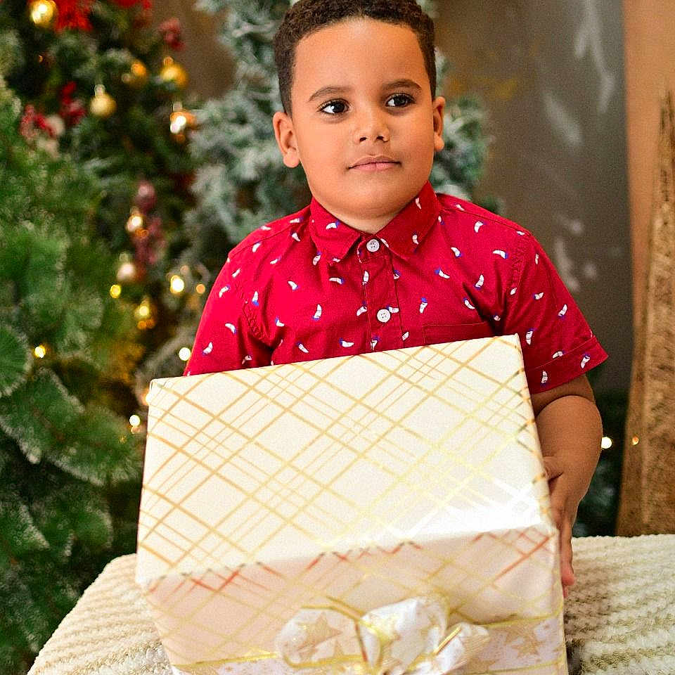 Yadiel Núñez joined the competition — help win amazing prizes! boy, celebration, child, christmas_tree, cute, decorations, festive, festivity, gift, happy, holiday, holiday_lights, indoor, portrait, present, red_shirt, seasonal, smiling, wrapped_box, young