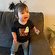 Elena joined the competition — help win amazing prizes! child, toddler, baby, smiling, happy, standing, portrait, indoors, living_room, couch, sofa, striped_leggings, black_shirt, ghost_design, halloween, pigtails, warm_lighting, houseplant, home_decor, photography