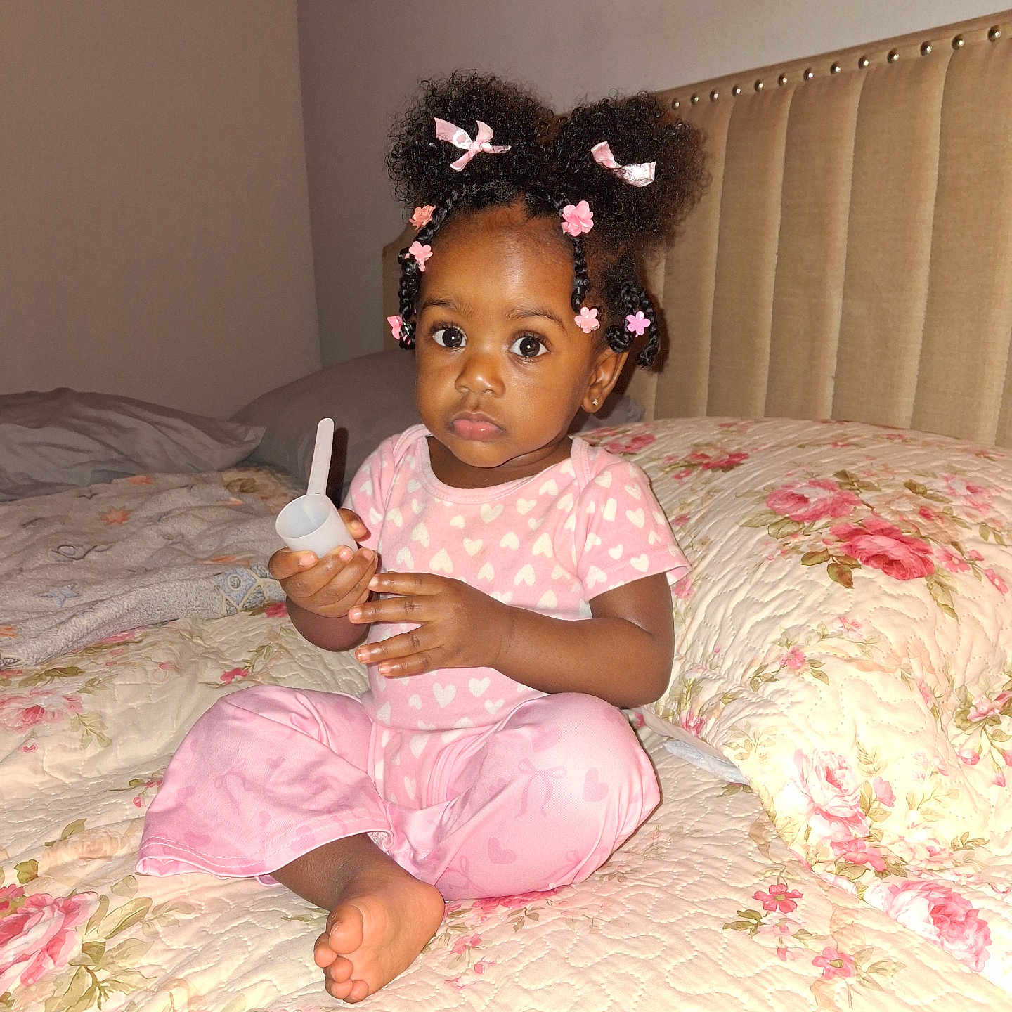 Jenaiah is registered to the contest to win money with this photo: barefoot, bed, bedroom, braids, child, curly_hair, floral_bedding, furniture, girl, hair_bows, hearts, indoors, pajamas, pink_clothing, portrait, scoop, sitting, smiling, toddler, toy
