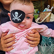 Roxane participe au concours pour gagner de l'argent avec cette photo : baby, child, eye_patch, pirate, pink_sweatshirt, barbie, tongue_out, smiling_person, braces, hands, holding, indoor, person, cute, playful, face, clothing, portrait, fun, expression