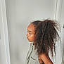 Awa a rejoint le concours — aidez-le/la à gagner de superbes lots ! child, girl, curly_hair, profile, sleeveless_shirt, standing, indoor, contemplative, serene, portrait, person, young, brown_skin, casual_clothing, natural_light, hair, fashion, side_view, human, alone