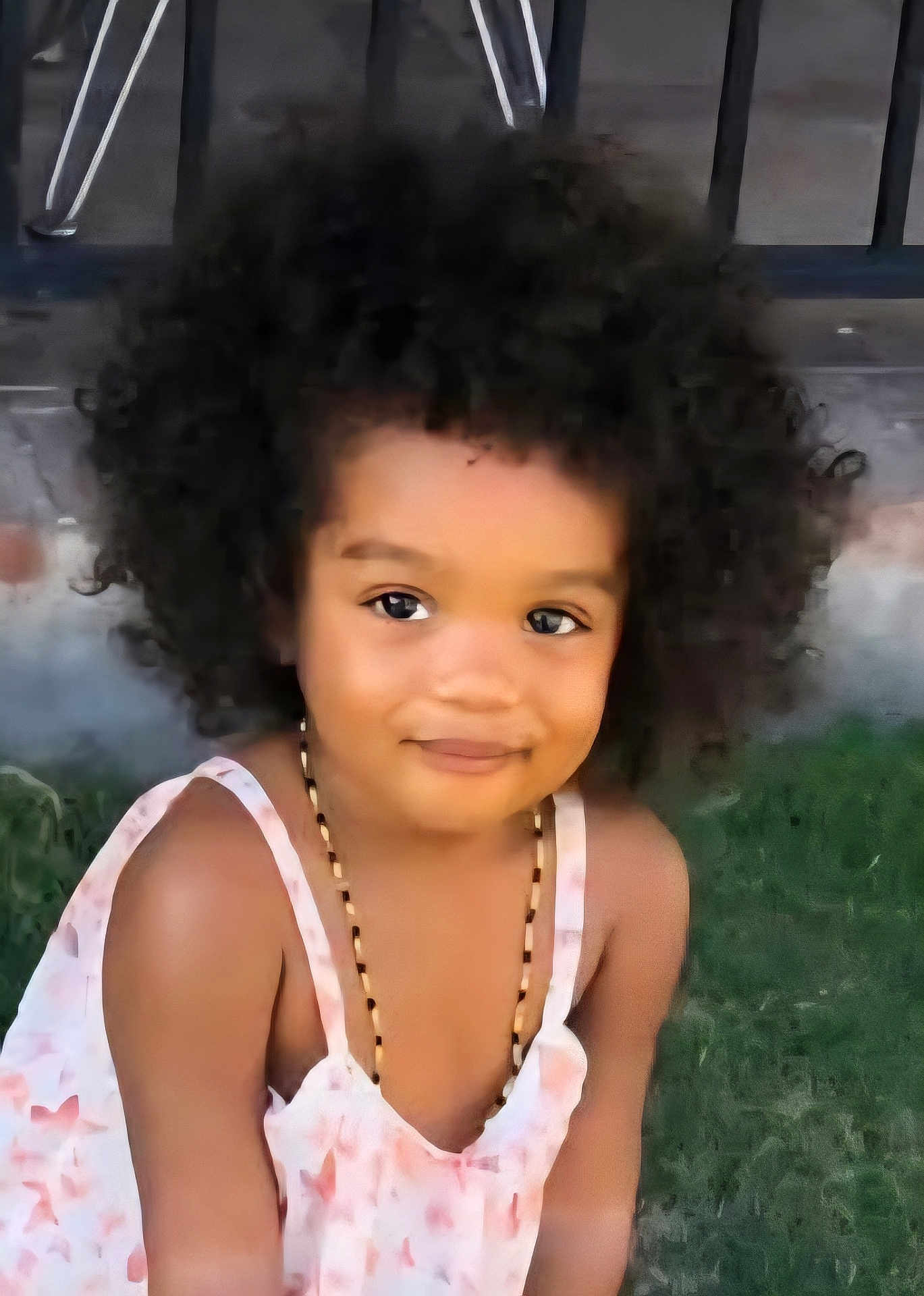 Awa a rejoint le concours — aidez-le/la à gagner de superbes lots ! child, curly_hair, afro, smile, outdoor, grass, dress, necklace, young, portrait, person, happy, sitting, fence, background, cute, skin, face, fashion, summer