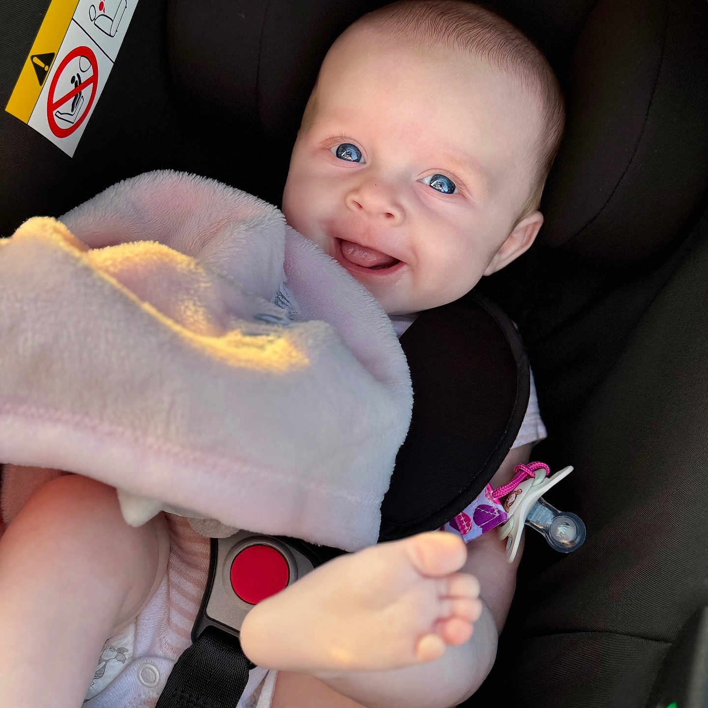 Amiya-Mae is registered to the contest to win money with this photo: baby, blanket, blue_eyes, car_seat, child, closeup, clothing, cute, foot, happy, head, indoor, infant, pacifier, pink, playful, safety_belt, seat, skin, smile