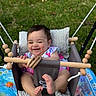 Rya joined the competition — help win amazing prizes! baby, child, swing, playful, smiling, outdoor, grass, toy, wooden_bar, cushion, happy, infant, feet, hands, play_mat, striped_cushion, colorful, summer, cute, portrait