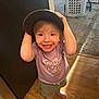 toddler, child, smiling, hat, barefoot, wooden_floor, shorts, tshirt, indoor, laundry_basket, carpet, cabinet, person, happy, cute, small_child, standing, light, shadow, home