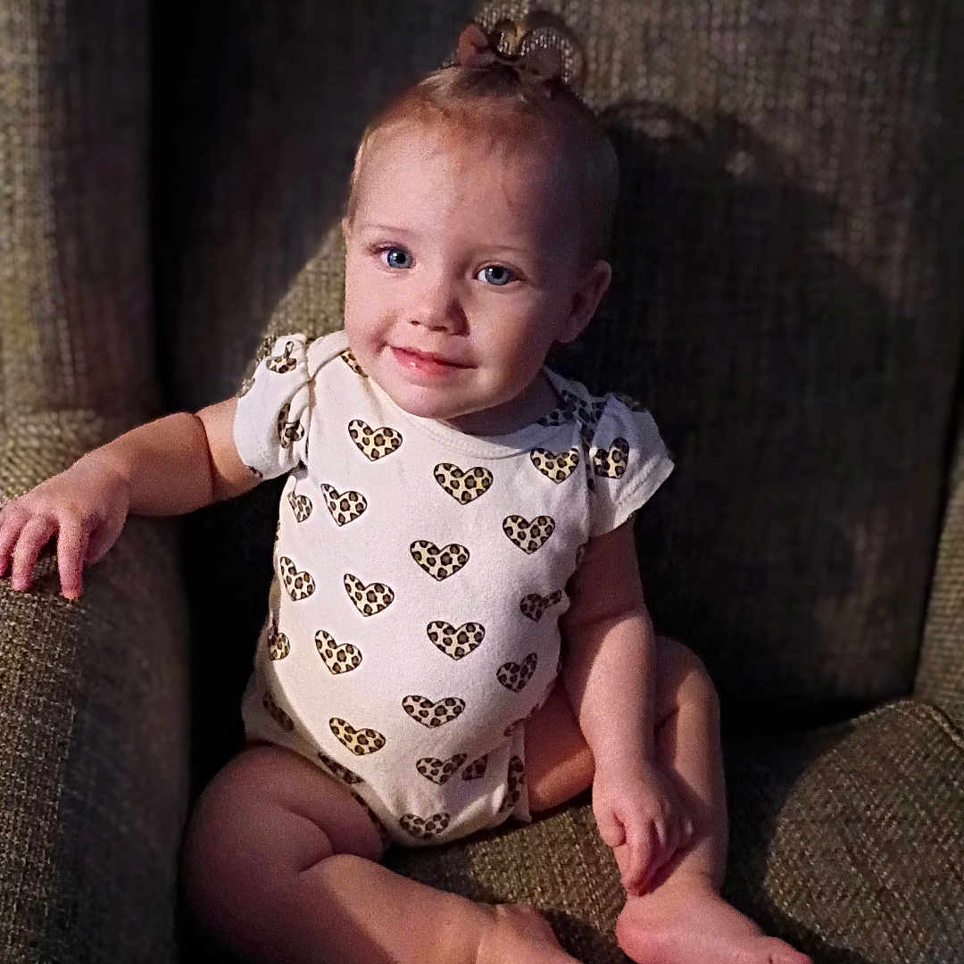 Kayetta joined the competition — help win amazing prizes! armchair, baby, barefoot, bow, child, cozy, cute, face, furniture, happy, heart_pattern, indoor, light_shadow, onesie, portrait, sitting, skin, smile, toddler, young_child