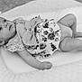 Ember is registered to the contest to win money with this photo: baby, infant, child, black_and_white, bow, headband, floral, clothing, lace, cushion, soft, portrait, lying_down, indoors, cute, newborn, expression, gaze, small, peaceful