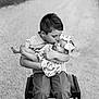 boy, baby, child, kiss, brother, sister, love, affection, chair, outdoor, portrait, black_and_white, flower_pattern, headband, cute, family, tender, holding, smiling, young