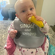 Aurora Jaide is registered to the contest to win money with this photo: baby, banana, bib, child, countertop, cute, drool, earring, eating, floral_print, highchair, indoor, infant, kitchen, nike_logo, onesie, portrait, sofa, teething, window