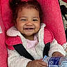 toddler, child, smiling, face, jacket, stroller, red, water_bottle, hand, outdoor, happy, person, baby, cute, clothing, seatbelt, portrait, curly_hair, cozy, playful