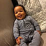 Jahleel participe au concours pour gagner de l'argent avec cette photo : baby, child, smile, striped_clothing, couch, quilt, indoor, happy, infant, person, seated, cozy, cute, home, furniture, soft, relaxed, portrait, one_person, casual