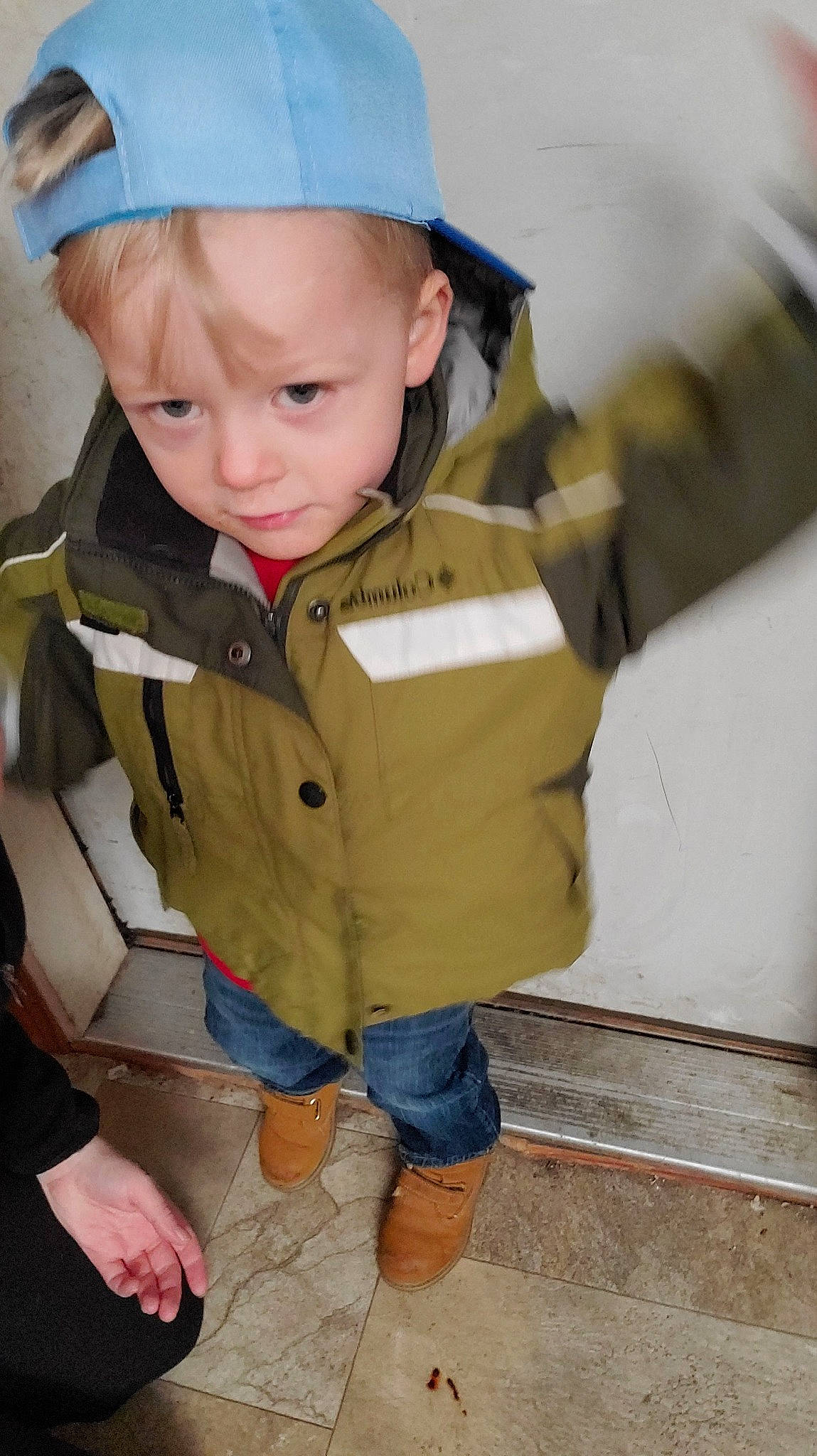 Jaxon is registered to the contest to win money with this photo: baby, baby_toddler_clothing, blond, cap, cheek, child, eye, fun, hairstyle, head, human_body, iris, outerwear, person, shorts, sitting, skin, sleeve, standing, toddler