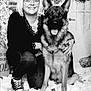 U'Sam participe au concours pour gagner de l'argent avec cette photo : black_and_white, casual, clothing, decorations, dog, festive, floor, german_shepherd, glasses, happy, holiday, indoors, pet, portrait, seated, smiling, snow, winter, woman, wreath