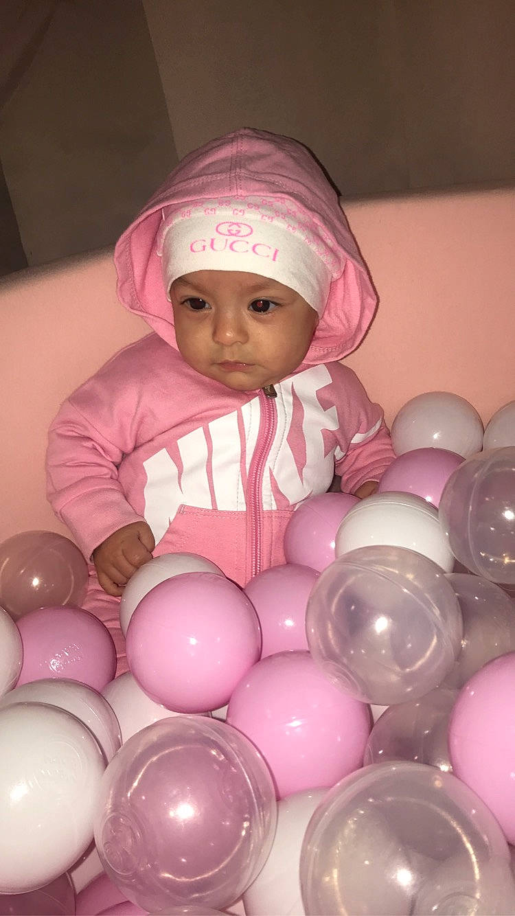 Kamelia a rejoint le concours — aidez-le/la à gagner de superbes lots ! baby, baby_toddler_clothing, ball, balloon, beanie, cap, child, circle, event, fun, happy, headwear, magenta, party, party_supply, person, pink, play, sphere, toddler