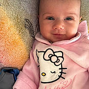 Véronique a rejoint le concours — aidez-le/la à gagner de superbes lots ! baby, infant, smile, face, pink_clothing, hello_kitty, blanket, soft_texture, cute, child, portrait, indoors, young_child, cozy, apparel, baby_girl, expression, close_up, resting, happiness