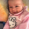 Véronique a rejoint le concours — aidez-le/la à gagner de superbes lots ! baby, infant, pink_clothing, hello_kitty, smile, face, eyes, blanket, soft_texture, cute, child, portrait, warm, cozy, apparel, person, young_child, indoors, happy, head