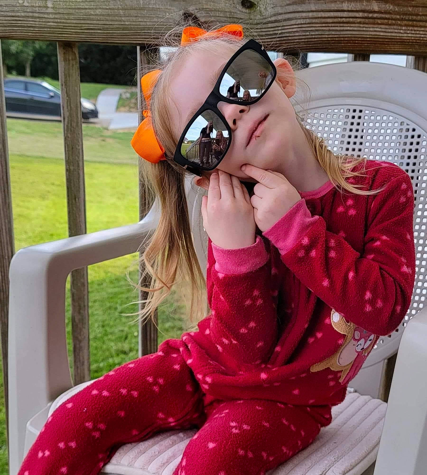 Sara is registered to the contest to win money with this photo: audio_equipment, black_hair, chair, comfort, eyewear, fun, goggles, happy, headgear, human_leg, leisure, magenta, person, personal_protective_equipment, pink, plant, shoulder, sunglasses, thigh, travel