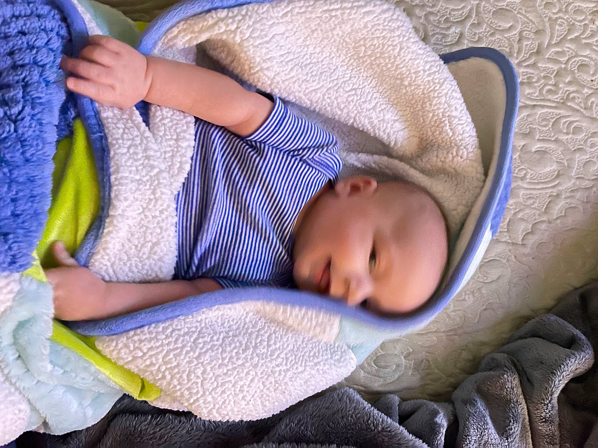 Balin is registered to the contest to win money with this photo: arm, baby, baby_products, baby_toddler_clothing, blue, cheek, child, comfort, electric_blue, hand, linens, nap, person, product, purple, sitting, sleeve, textile, toddler, tree