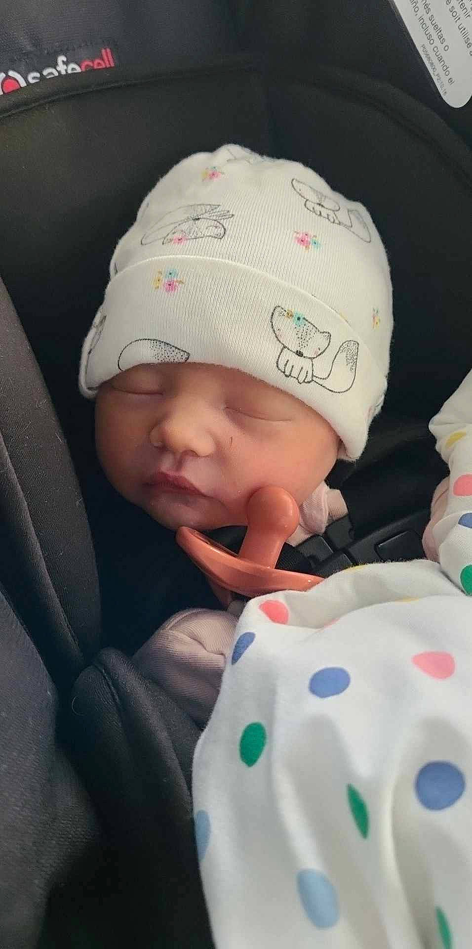 Olivia is registered to the contest to win money with this photo: baby, baby_products, baby_sleeping, baby_toddler_clothing, beanie, cap, cheek, child, comfort, happy, headgear, headwear, knit_cap, linens, pattern, person, sitting, skin, sleeve, textile