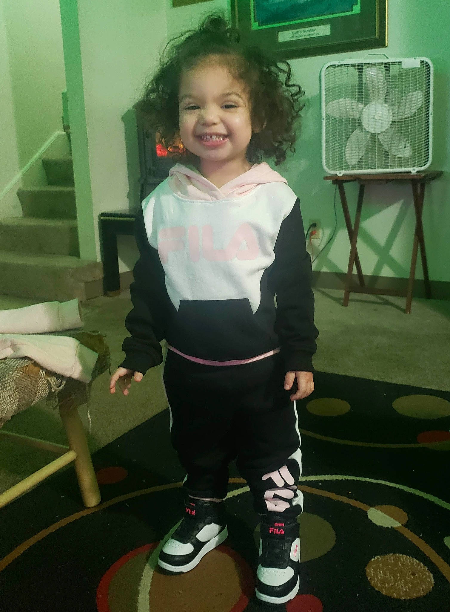 Amiah Faith is registered to the contest to win money with this photo: baby_toddler_clothing, balance, chair, child, flooring, fun, head, human_leg, joy, knee, person, room, sleeve, smile, snapshot, sneakers, sock, sportswear, t_shirt, television