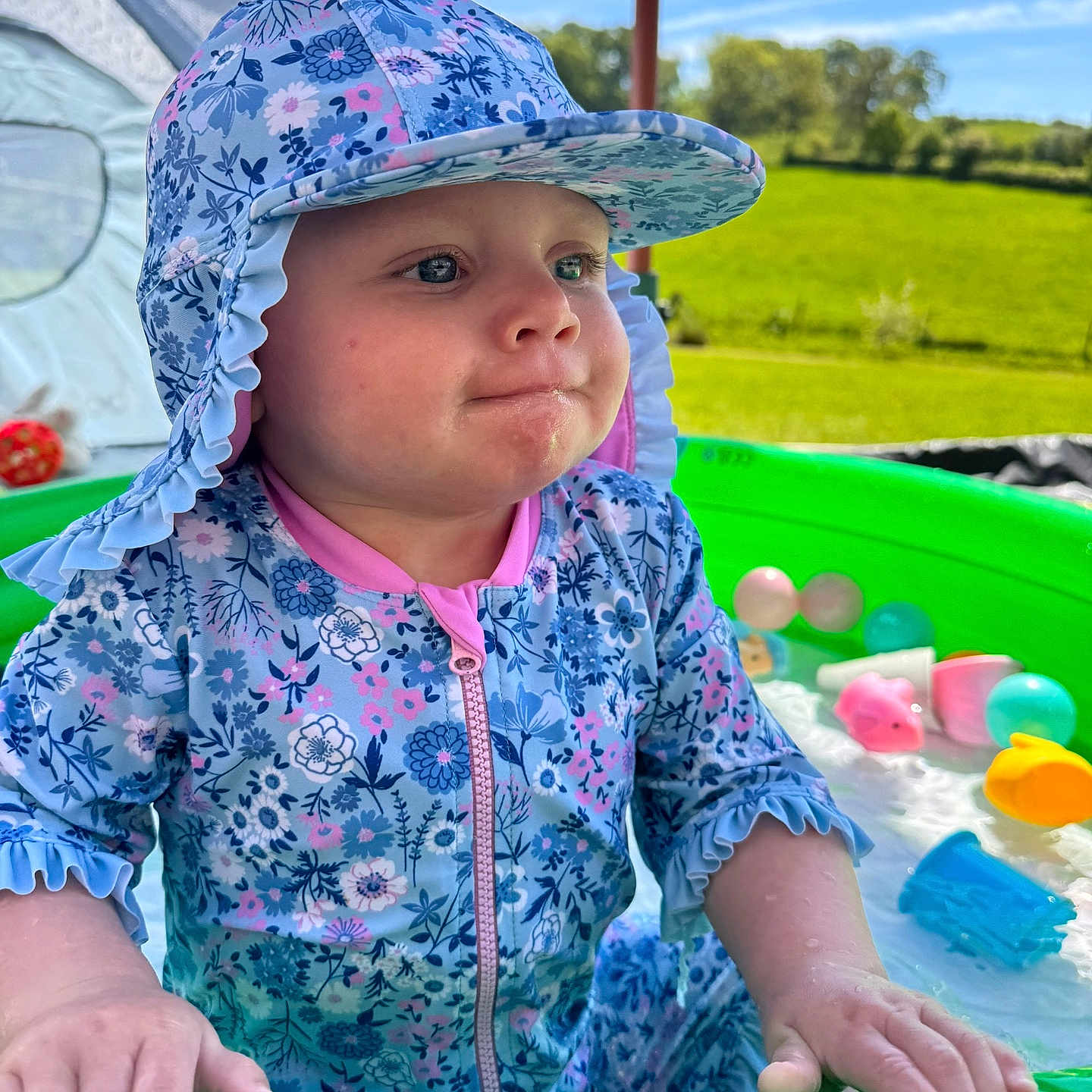 Evie joined the competition — help win amazing prizes! baby, bodypart, bonnet, cap, clothing, face, finger, grass, hand, hat, head, outdoorplayarea, outdoors, person, photography, plant, playarea, portrait, summer, sunhat