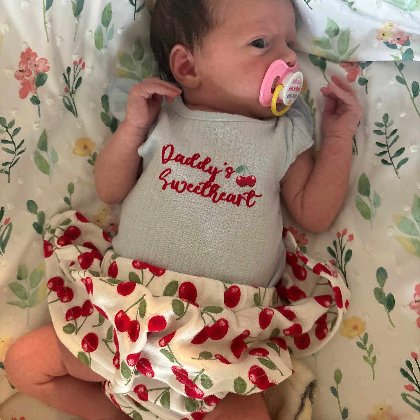 Savannah is registered to the contest to win money with this photo: baby, baby_girl, bed, blanket, cherry_pattern, clothing, cute, cute_outfit, floral, foot, hand, infant, lying_down, newborn, pacifier, person, resting, skin, sleepwear, soft