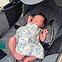 Savannah is registered to the contest to win money with this photo: newborn, baby, sleeping, stroller, dress, floral_pattern, quilted, gray, infant, peaceful, child, cute, relaxed, footwear_absent, indoors, comfort, resting, small, person, toddler