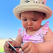 Melina participe au concours pour gagner de l'argent avec cette photo : baby, child, hat, straw_hat, sunglasses, pink_clothing, outdoor, blue_sky, cute, summer, sunny, portrait, infant, face, looking_down, hands, closeup, person, childhood, nature