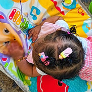 Ka'Hari joined the competition — help win amazing prizes! baby, child, hair_clips, play_mat, toys, colorful, giraffe, carpet, hand, pink_clothing, patterned_clothing, infant, indoors, floor, playing, cute, curly_hair, bright_colors, baby_toy, toddler