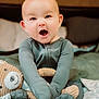 Beckett joined the competition — help win amazing prizes! baby, child, teddy_bear, bed, blanket, pajamas, smiling_toy, cute, indoors, portrait, infant, cozy, expression, soft_toy, sitting, clothing, person, young_child, happy, face