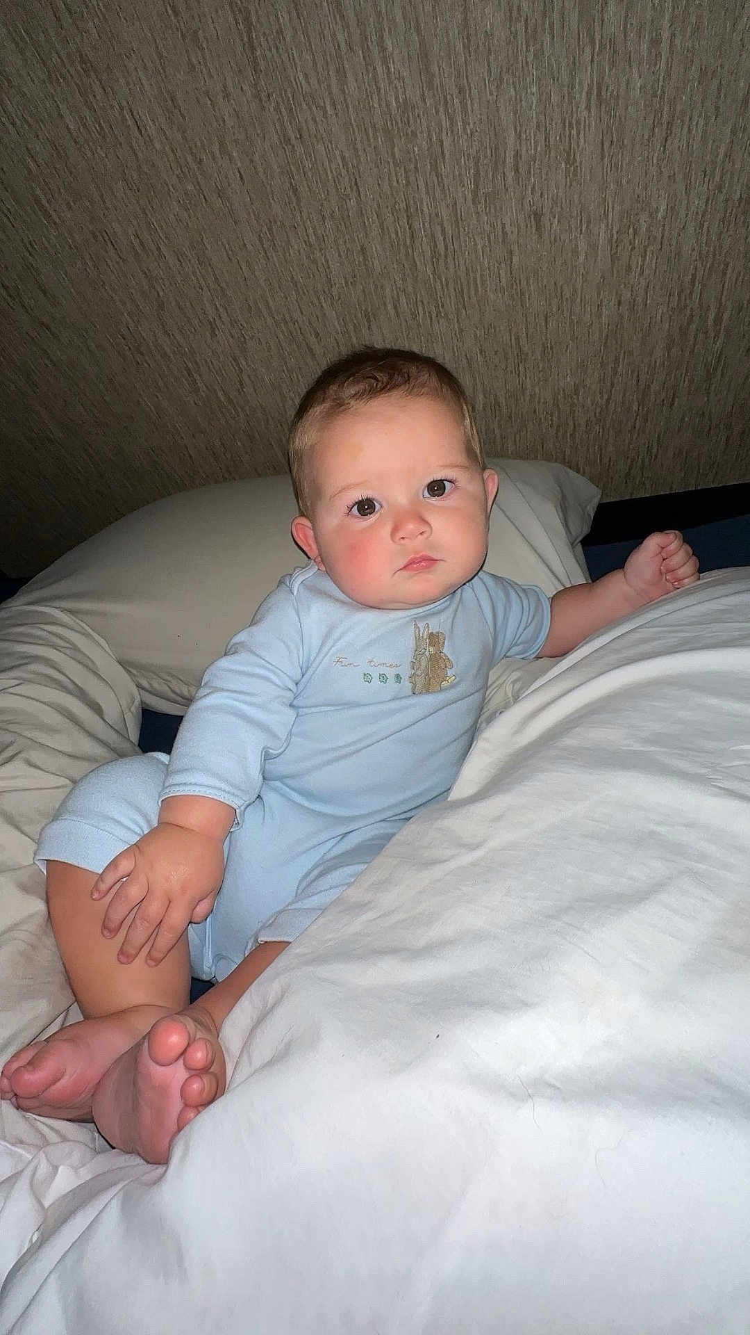 Beckett joined the competition — help win amazing prizes! baby, child, infant, bed, pillow, blue_onesie, barefoot, cute, portrait, indoor, skin, face, hand, foot, relaxed, looking_at_camera, young_child, sleepwear, lying_down, cozy