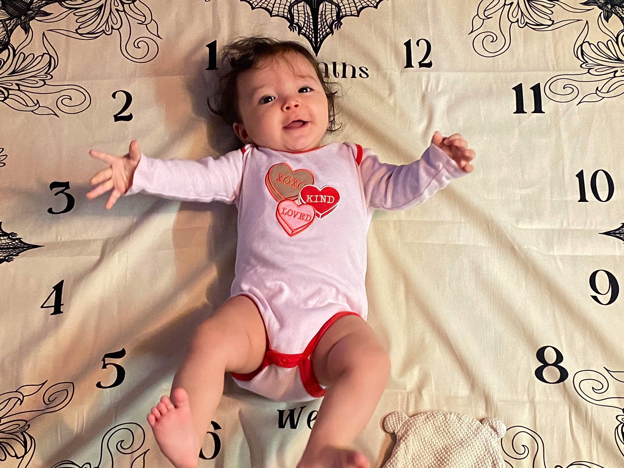 Helena is registered to the contest to win money with this photo: arm, baby, baby_toddler_clothing, cheek, child, eye, flash_photography, font, fun, gesture, happy, human_leg, pattern, person, pink, sleeve, smile, t_shirt, thigh, thumb