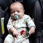 Calob Dennis Jr is registered to the contest to win money with this photo: baby, pacifier, car_seat, onesie, infant, sleepy, child, cute, face, clothing, seat, indoor, person, young_child, baby_girl, baby_boy, comfort, adorable, child_care, resting