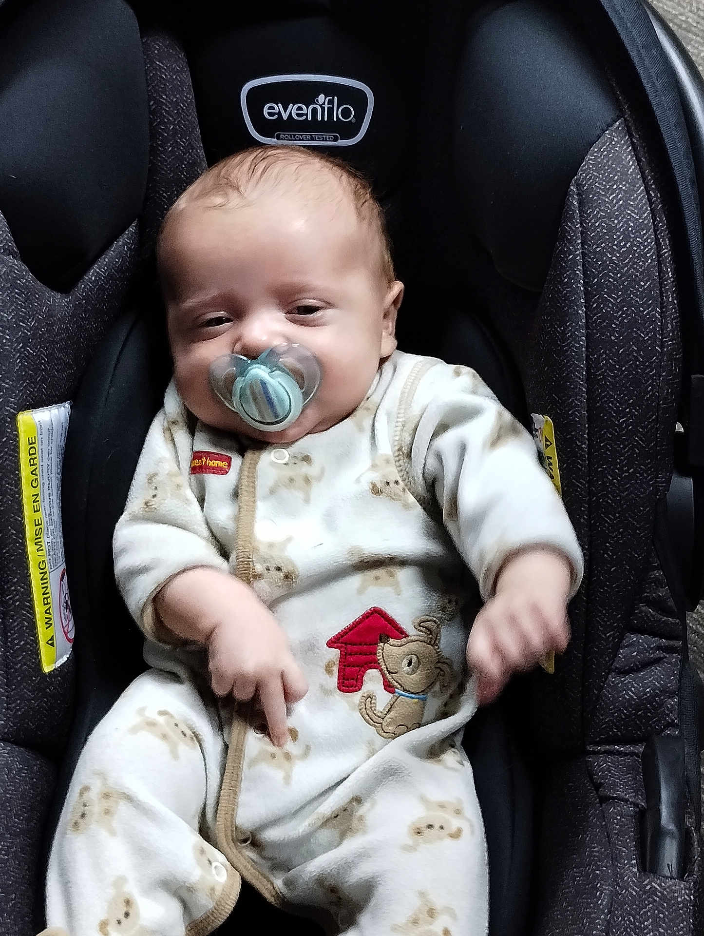 Calob Dennis Jr is registered to the contest to win money with this photo: baby, pacifier, car_seat, onesie, infant, sleepy, child, cute, face, clothing, seat, indoor, person, young_child, baby_girl, baby_boy, comfort, adorable, child_care, resting