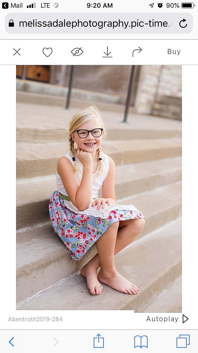 Bergit is registered to the contest to win money with this photo: child, design, dress, eyewear, facial_expression, finger, glasses, joy, pattern, person, photo_caption, photograph, photography, pink, portrait, portrait_photography, sitting, smile, stock_photography, text